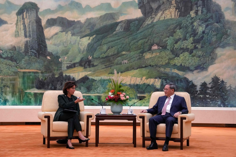 China's Premier Li Qiang (right) speaks with US Commerce Secretary Gina Raimondo during their meeting at the Great Hall of the People in Beijing on August 29, 2023. (Photo by Andy Wong / POOL / AFP)