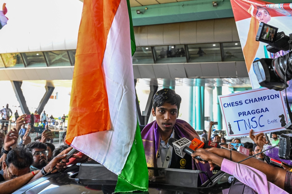 India's chess grandmaster and silver medallist Rameshbabu Praggnanandhaa, responds to a television media personnel as he is welcomed upon his return from the FIDE Chess World Cup in Baku, at the Chennai International airport in Chennai, on August 30, 2023. (Photo by AFP)