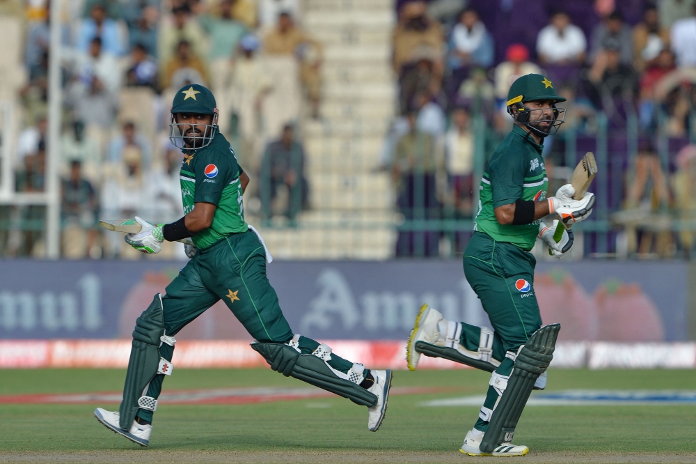 Pakistan's captain Babar Azam (L) and Iftikhar Ahmed run between the wickets during the Asia Cup 2023 cricket match between Pakistan and Nepal at the Multan Cricket Stadium in Multan on August 30, 2023. (Photo by Asif HASSAN / AFP)
