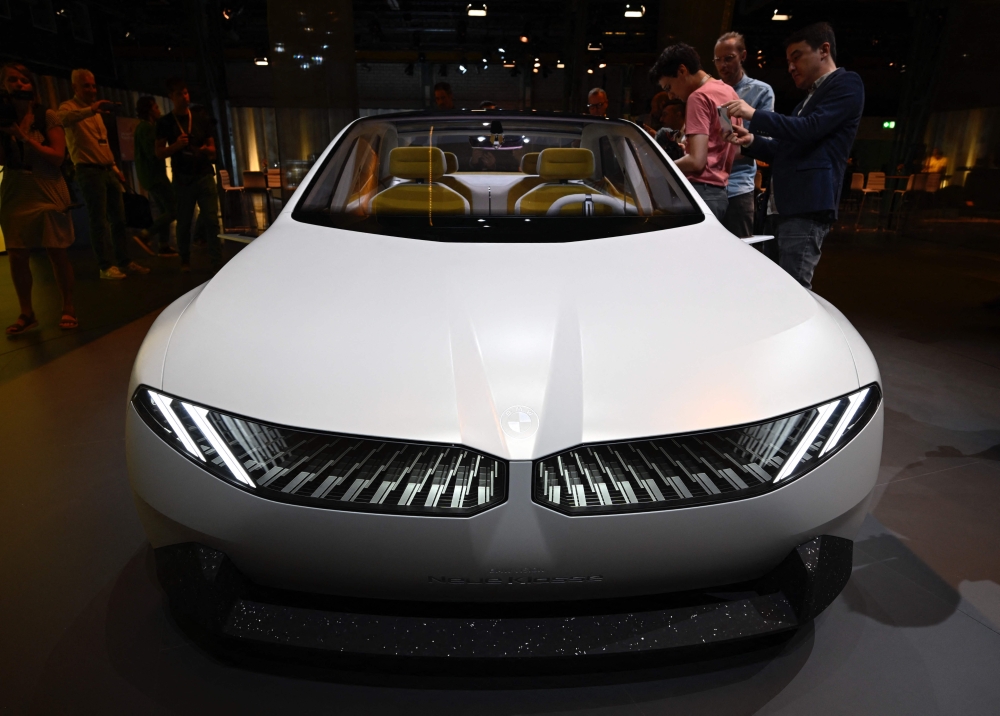 Visitors take pictures of a study of the 'Neue Klasse' (New Class) project, the new electric vehicle concepts, is seen during a preview event in Munich on September 2, 2023, on the eve of the opening of the Munich Motor Show (IAA) on September 4, 2023. (Photo by Tobias SCHWARZ / AFP)
