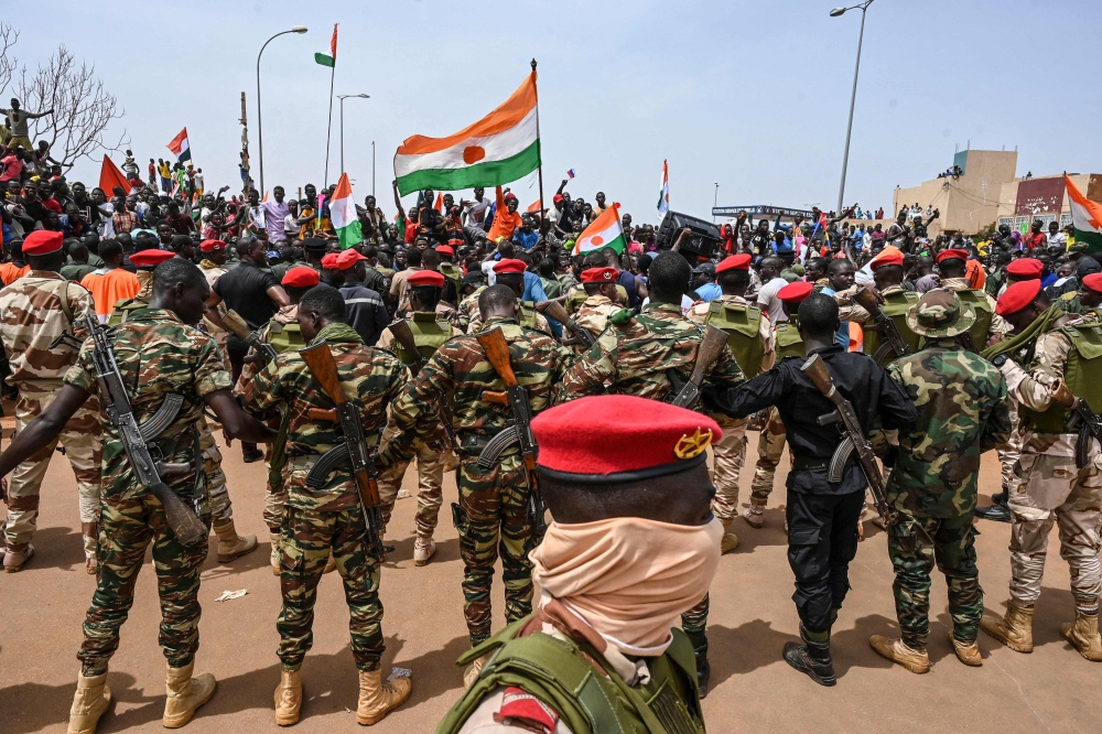 Nigerien soldiers stand guard as supporters of Niger's National Council of Safeguard of the Homeland (CNSP) protest outside the Niger and French airbase in Niamey on September 2, 2023 to demand the departure of the French army from Niger. (Photo by AFP)
