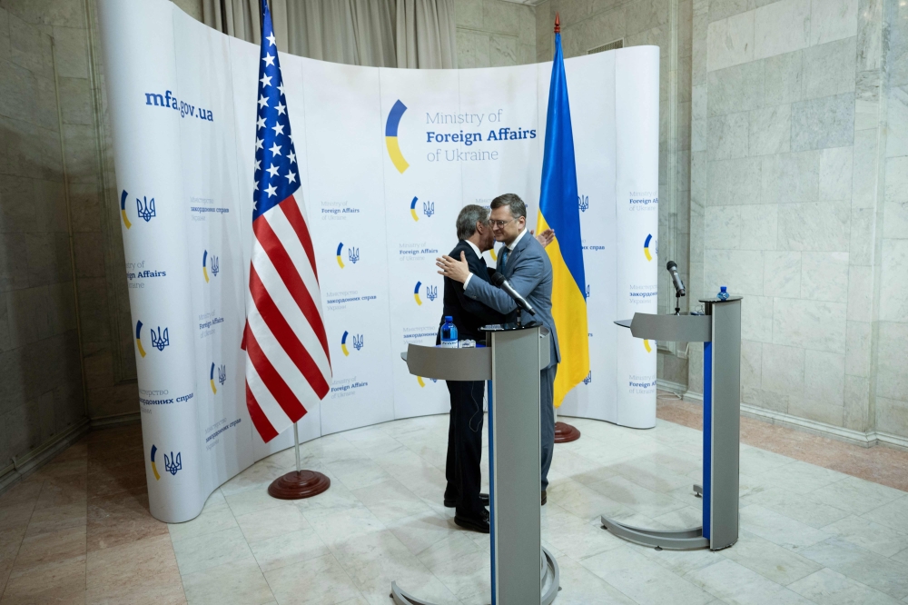 Ukraine's Foreign Minister Dmytro Kuleba (right) and US Secretary of State Antony Blinken embrace at the end of their joint press conference at the Ministry of Foreign Affairs in Kyiv on September 6, 2023. (Photo by Brendan Smialowski / POOL / AFP)