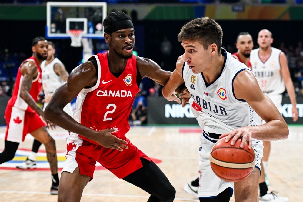 Serbia's Bogdan Bogdanovic (R) blows past Canada's Shai Gilgeous-Alexander (L) during the FIBA Basketball World Cup semi-final match between Serbia and Canada in Manila on September 8, 2023. (Photo by SHERWIN VARDELEON / AFP)