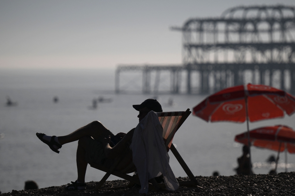 Beachgoers enjoy the sun and the sea on the beach at Brighton, on the south coast of England on September 7, 2023, as the late summer heatwave continues. (Photo by Daniel LEAL / AFP)