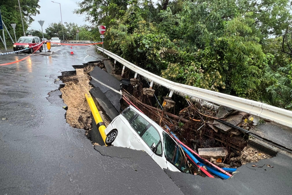  This picture shows a vehicle in a collapsed section of road in Hong Kong on September 8, 2023. (Photo by AFP)
