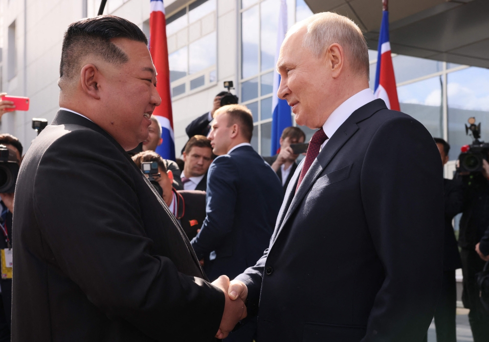 In this pool photo distributed by Sputnik agency, Russia's President Vladimir Putin (R) shakes hands with North Korea's leader Kim Jong Un (L) on September 13, 2023. (Photo by Mikhail Metzel / POOL / AFP)