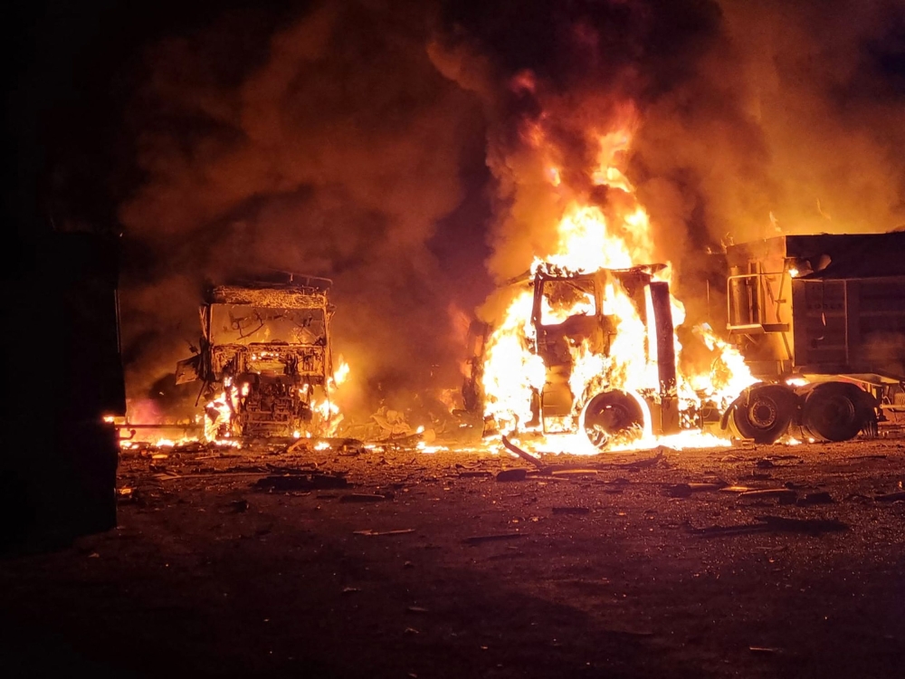 This handout photograph taken and released on September 13, 2023 by the press center of the Defense Forces of Southern Ukraine shows burning trucks following Russian drone attacks in Odesa region, amid Russia's military invasion on Ukraine. (Photo by Handout / press center of Defense Forces of the Southern Ukraine / AFP) 
