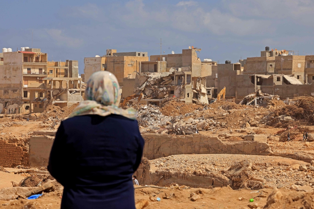 A survivor looks at the rubble of destroyed buildings in Libya's eastern city of Derna on September 18, 2023 following deadly flash floods. (Photo by Karim Sahib / AFP)