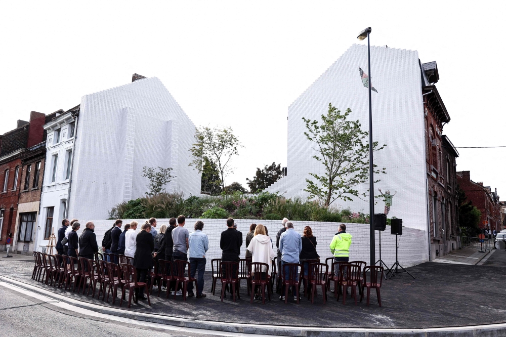 People observe a minute of silence during the inauguration of a Memorial garden dedicated to victims of serial child-killer Marc Dutroux in Charleroi. (Photo by Kenzo Tribouillard / AFP)
