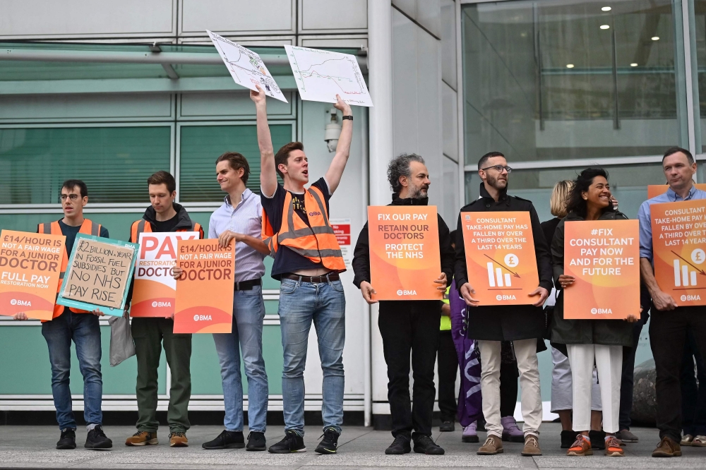 National Health Service workers hold placards at a picket line outside University College Hospital in central London on September 20, 2023. (Photo by Justin Tallis / AFP)