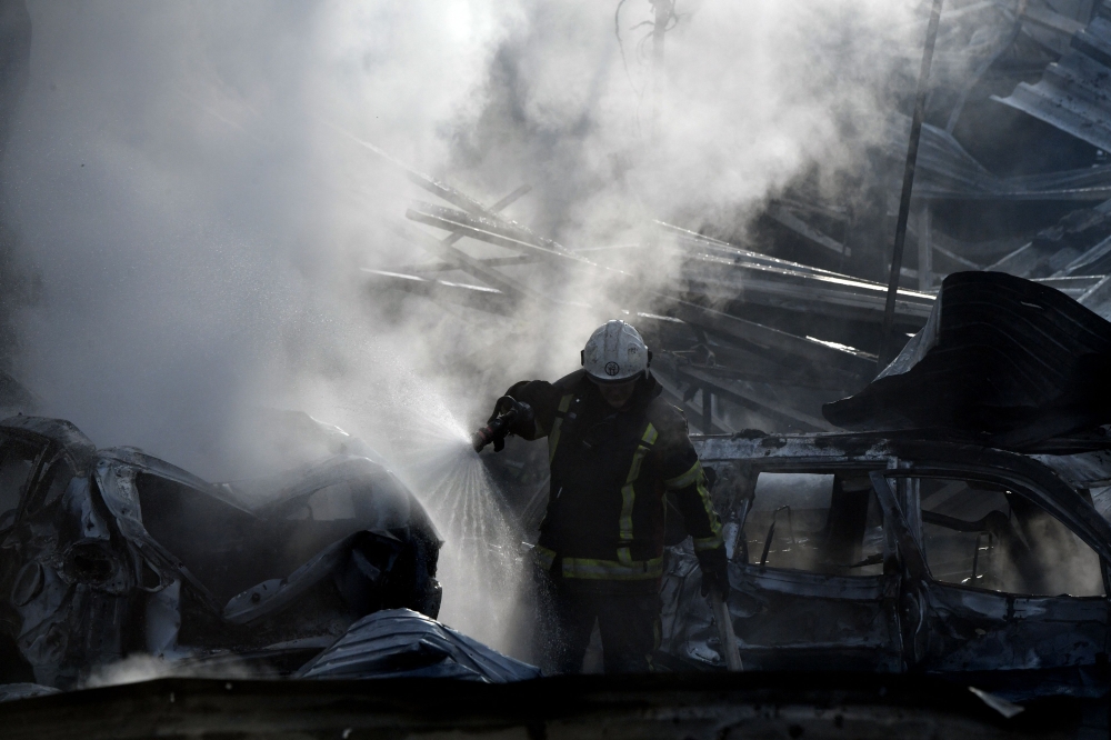 Firefighters push out a fire on an industrial area of the Ukrainian capital of Kyiv, after a massive overnight missile attack to Ukraine on September 21, 2023. (Photo by Sergei Supinsky / AFP)