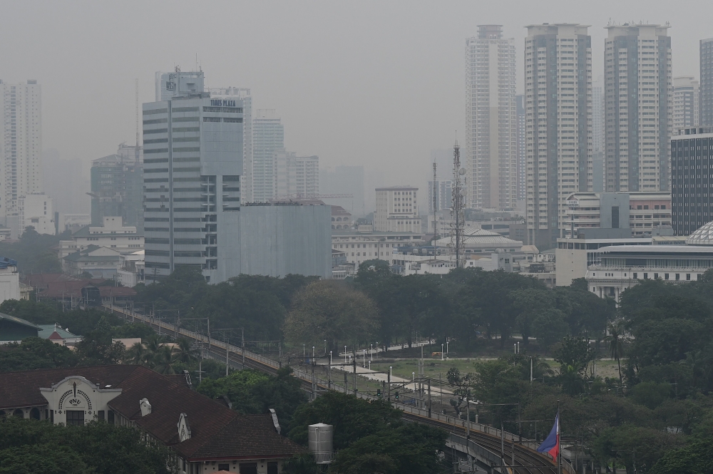 The Manila skyline is seen shrouded in smog on September 22, 2023. (Photo by JAM STA ROSA / AFP)
