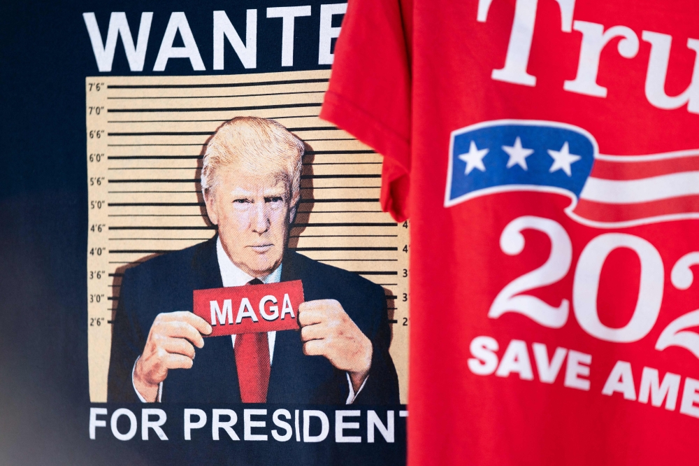 T-shirts seen for sale before a campaign rally with former US President Donald Trump on September 25, 2023 in Summerville, South Carolina. (Photo by Sean Rayford / Getty Images via AFP)