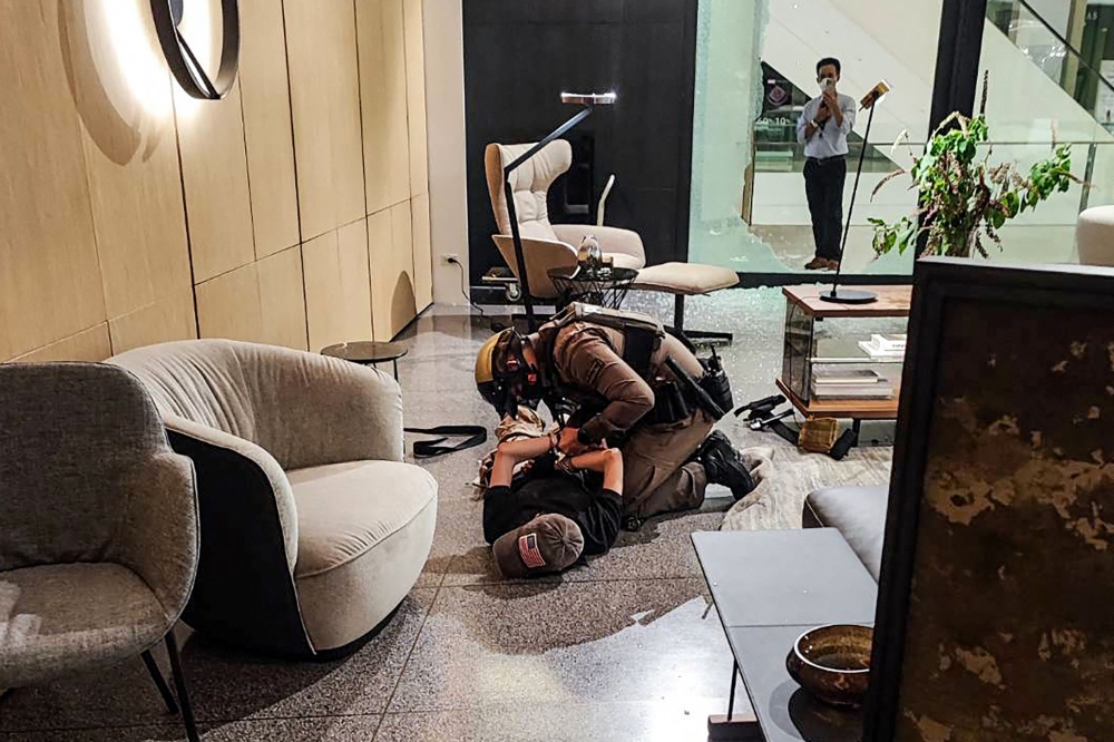 This handout from the Central Investigation Bureau of the Royal Thai Police released on October 3, 2023, shows the arrest of a 14-year-old boy suspect of a shooting at Siam Paragon shopping centre in Bangkok. (Photo by Handout / Central Investigation Bureau of the Royal Thai Police / AFP)