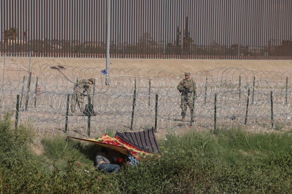 Border Patrol agents stand guard as migrant people cross the Rio Grande to seek asylum in the US, as seen from Ciudad Juarez, Chihuahua state, Mexico on October 3, 2023. (Photo by HERIKA MARTINEZ / AFP)
