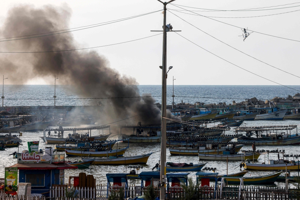A plume of smoke rises above the port in the Gaza Strip after an Israeli air strike, on October 8, 2023. (Photo by MOHAMMED ABED / AFP)

