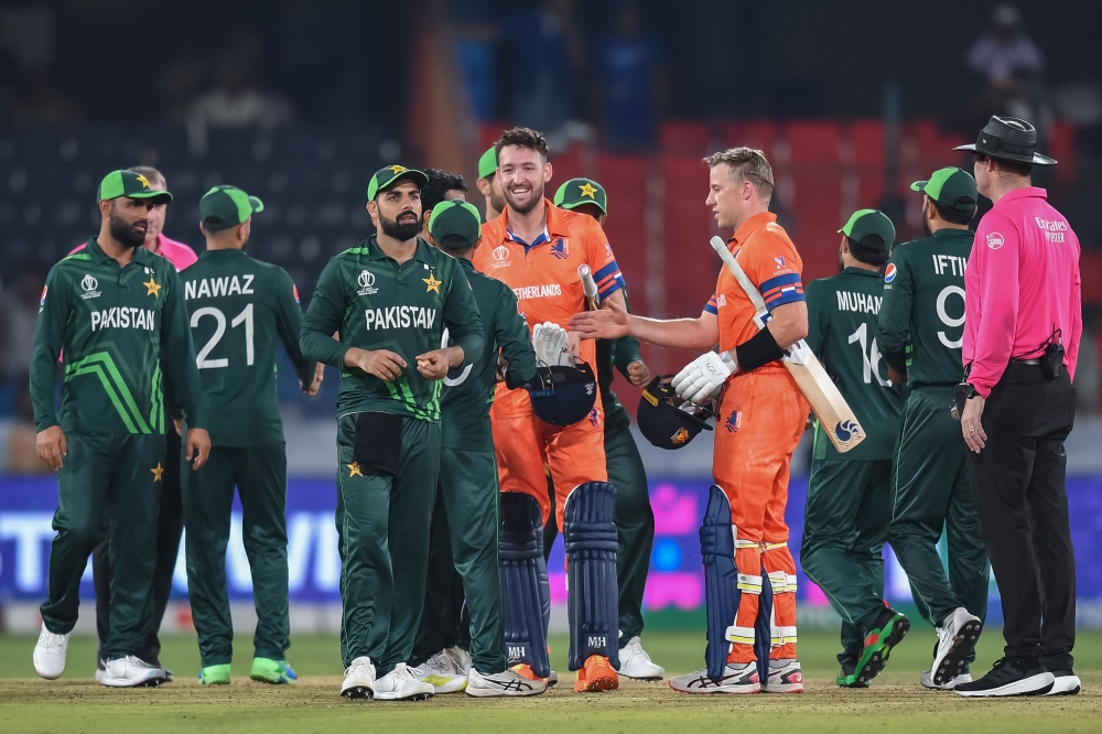 Netherlands' Logan van Beek (4R) and Paul van Meekeren (C) shake hands with Pakistan's players at the end of the 2023 ICC Men's Cricket World Cup one-day international (ODI) match between Pakistan and Netherlands on October 6, 2023. (Photo by Noah Seelam / AFP)
