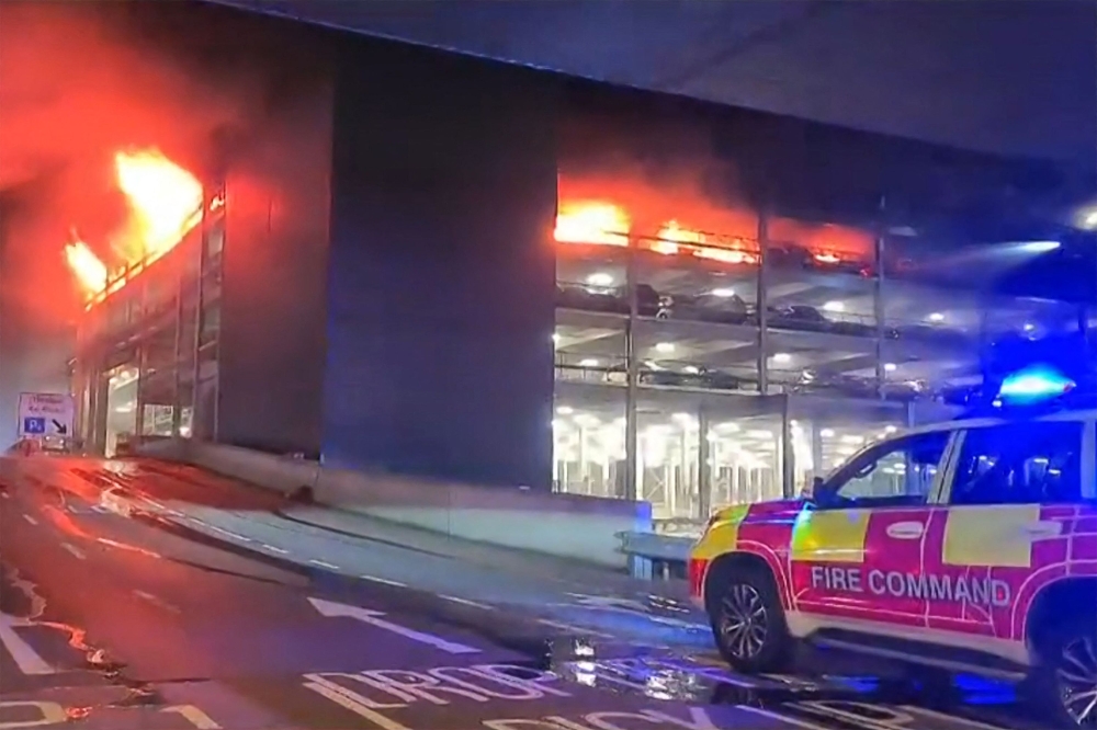 This frame grab from handout video footage taken and released by the Bedfordshire Fire and Rescue Service via AFPTV on October 11, 2023 shows a parking structure on fire at London's Luton Airport. Photo by Handout / various sources / AFP