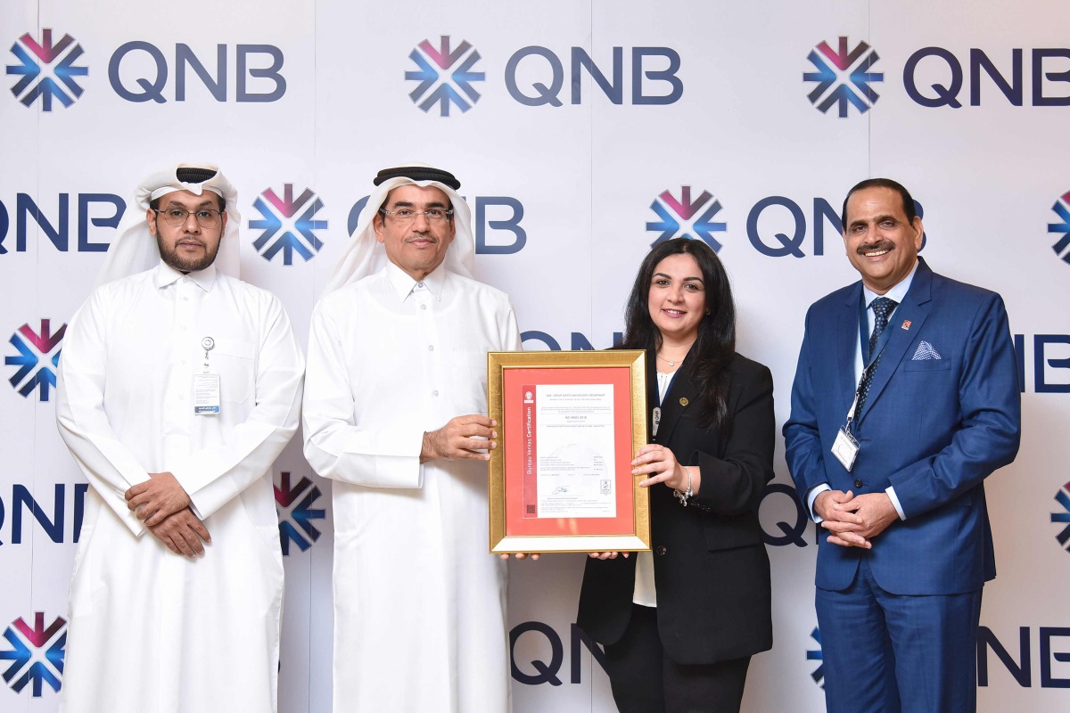 Senior Executive Vice President, QNB Group Projects & General Services Division, Yousef Ali Al Darwish (second left) and other officials with the ISO certification.