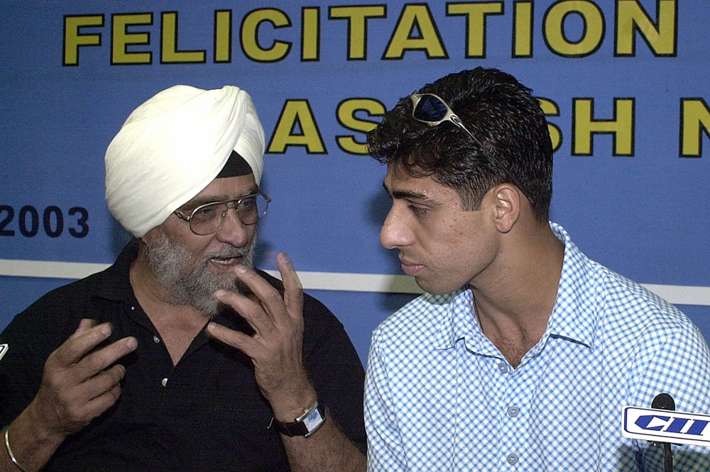 (Files) In this file photo taken on April 4, 2003, former India's cricket captain and spinner Bishan Singh Bedi (L) speaks with fast bowler Ashish Nehra during a felicitation ceremony in New Delhi. (Photo by Ravi Raveendran / AFP)