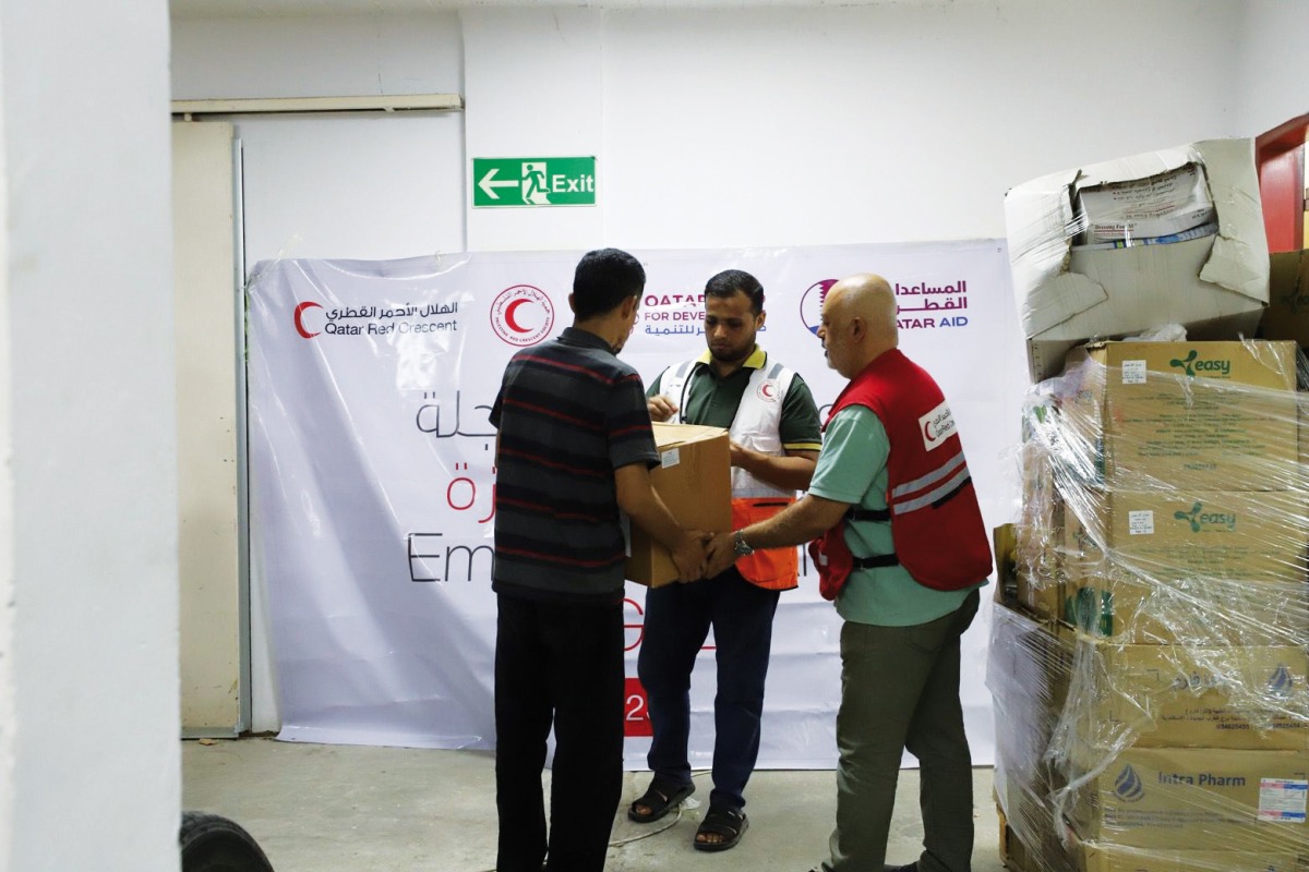 QRCS team distributing food parcels to Palestinians sheltered at the Al Amal Hospital in Khan Yunis governorate.