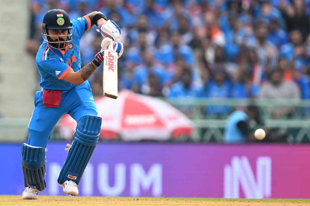 India's Virat Kohli watches the ball after playing a shot during the 2023 ICC Men's Cricket World Cup one-day international (ODI) match between India and England at the Ekana Cricket Stadium in Lucknow on October 29, 2023. (Photo by Sajjad HUSSAIN / AFP) 
