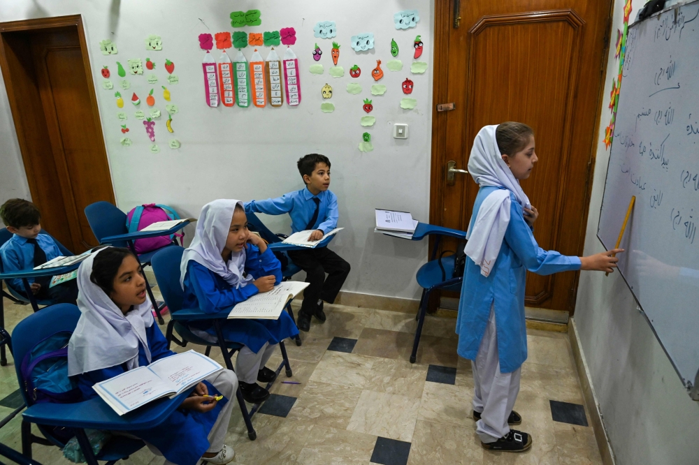 Afghan refugee children attend a class at Estiqlal Lycee High School in Islamabad on October 30, 2023. (Photo by Aamir Qureshi / AFP)