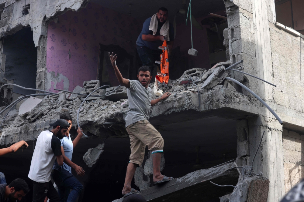 People search for victims in a building hit by Israeli bombing in Rafah in the southern Gaza Strip, on November 11, 2023. Photo by SAID KHATIB / AFP