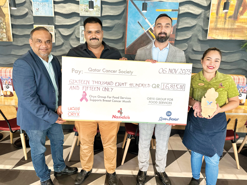 Nando's officials with display cheque of the cash donation in support of the Breast Cancer Awareness 