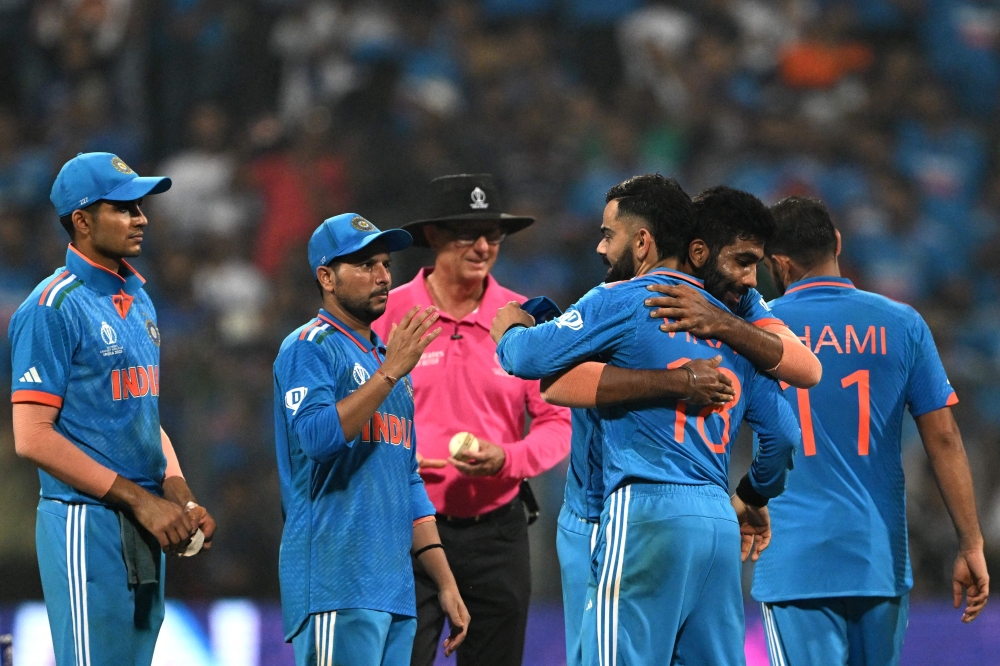 India's players celebrate their victory at the end of the 2023 ICC Men's Cricket World Cup one-day international (ODI) first semi-final match between India and New Zealand at the Wankhede Stadium in Mumbai on November 15, 2023. (Photo by Punit PARANJPE / AFP)