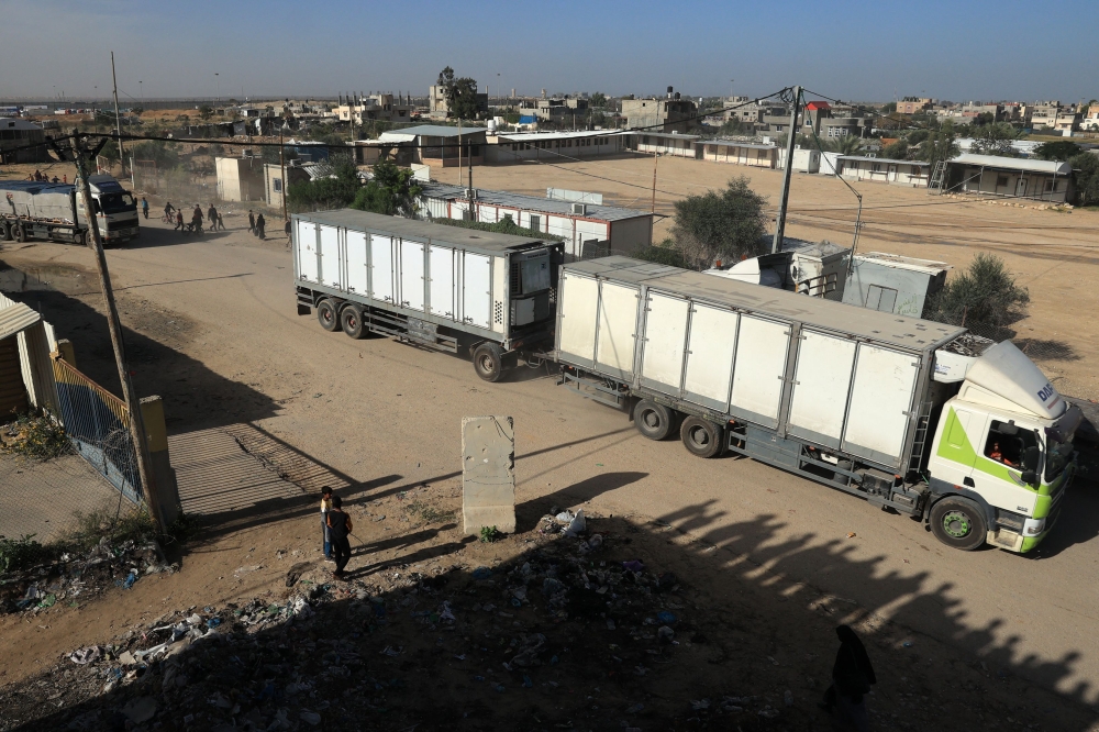 Trucks carrying humanitarian aid enter the Gaza Strip via the Rafah crossing with Egypt, hours after the start of a four-day truce, on November 24, 2023. Photo by SAID KHATIB / AFP