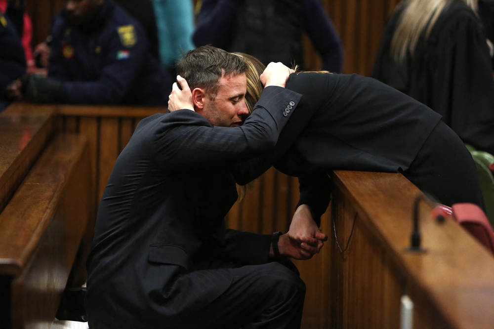(FILES) South African Paralympian Oscar Pistorius reacts as his sister holds him during the third day of his resentencing hearing for the 2013 murder of his girlfriend Reeva Steenkamp at the Pretoria High Court, in Pretoria on June 15, 2016. (Photo by Alon Skuy / POOL / AFP)
