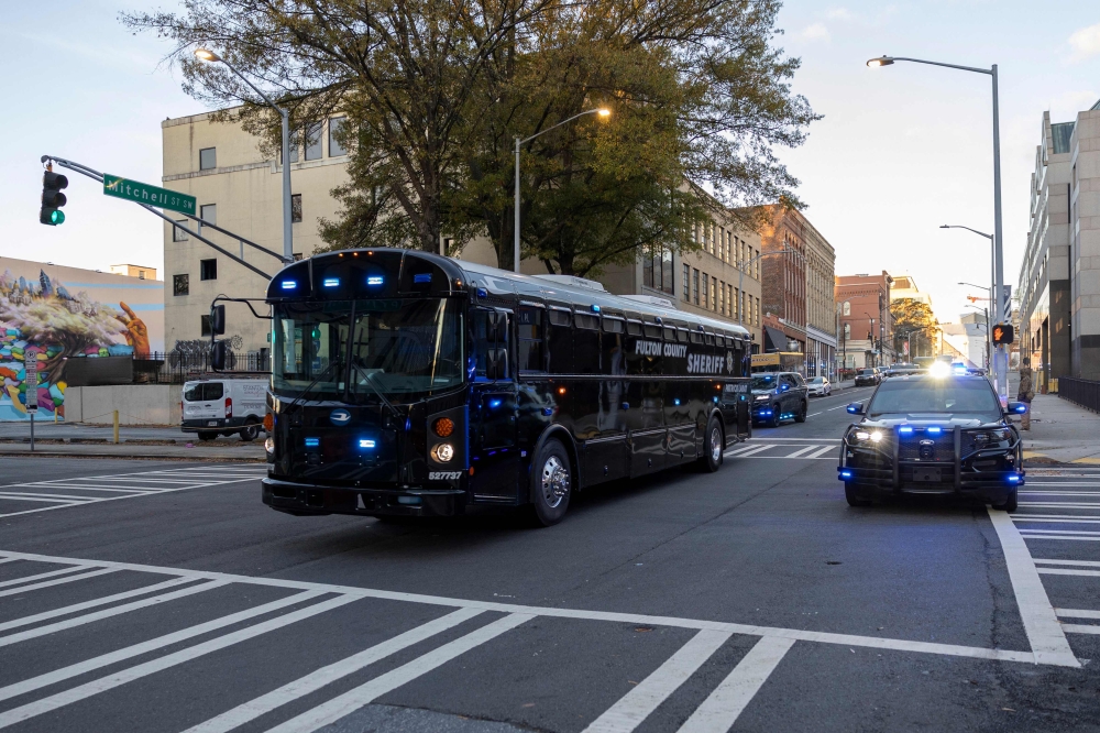 A convoy of police vehicles transporting prisoners enters the Fulton County Courthouse on November 27, 2023 in Atlanta, Georgia. (Photo by Christian MONTERROSA / AFP)
