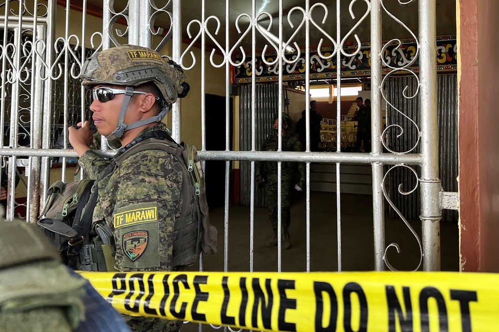 Military personnel stand guard at the entrance of a gymnasium while police investigators look for evidence after a bomb attack at Mindanao State University in Marawi, Lanao del sur province on December 3, 2023.(Photo by Merlyn Manos / AFP)