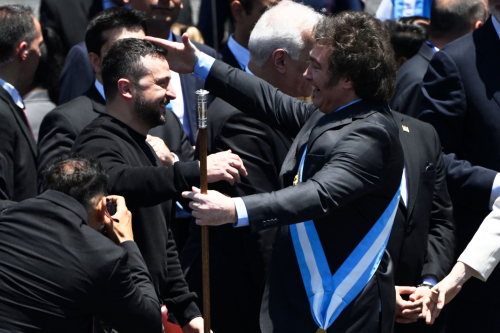 Argentina's new president Javier Milei (R) is greeted by Ukraine's President Volodymyr Zelensky after delivering his inaugural speech before the crowd during an inauguration ceremony at the Congress in Buenos Aires on December 10, 2023. (Photo by Luis ROBAYO / AFP)
