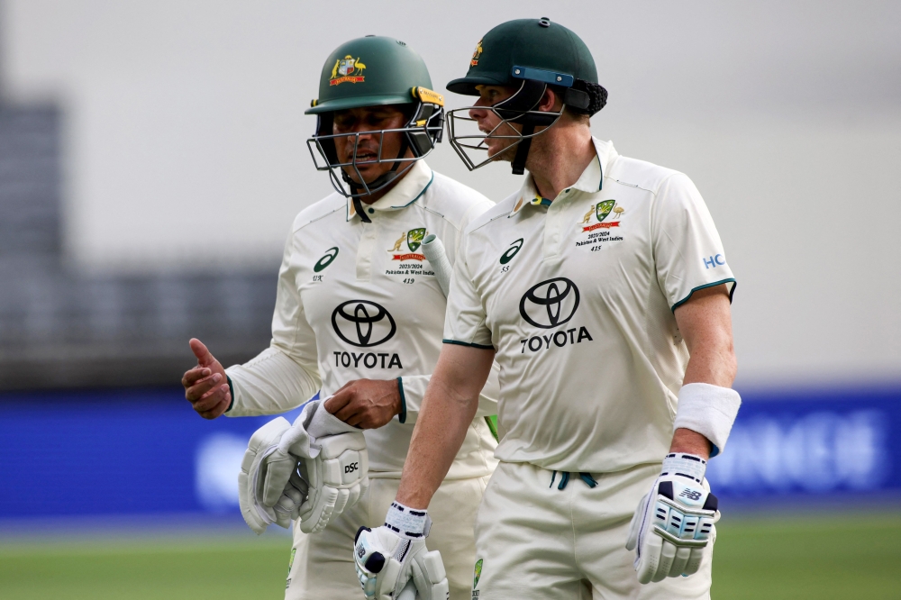 Australia's Usman Khawaja (L) and teammate Steve Smith walk off at close of play on day three in Perth on December 16, 2023. (Photo by Colin Murty / AFP) 
