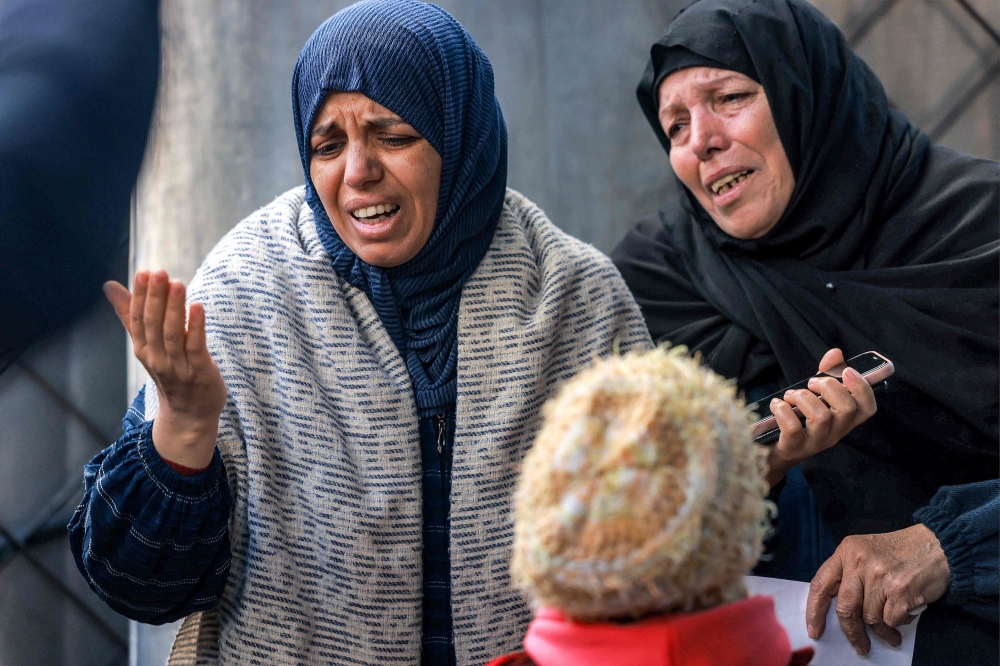 Women mourn the loss of loved ones who were killed overnight during Israeli bombardment, at a hospital in Rafah in the southern Gaza Strip on December 19, 2023. Photo by MOHAMMED ABED / AFP