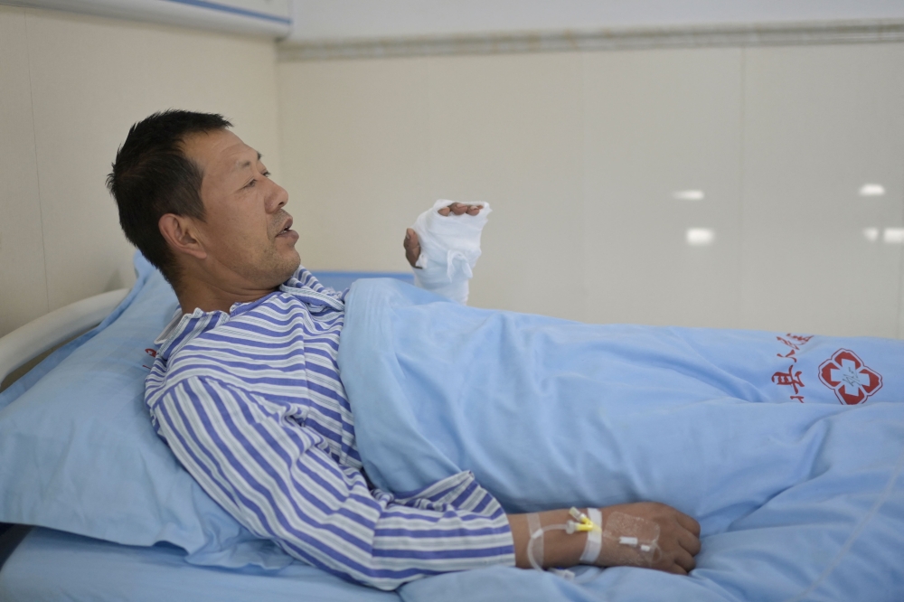 A patient with injuries following an earthquake remains under observation at a hospital in Dahejia in Jishishan County in northwest China's Gansu province on December 21, 2023. (Photo by Pedro Pardo / AFP)
