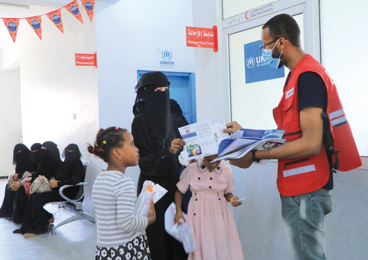 A QRCS representative distributes health awareness materials.