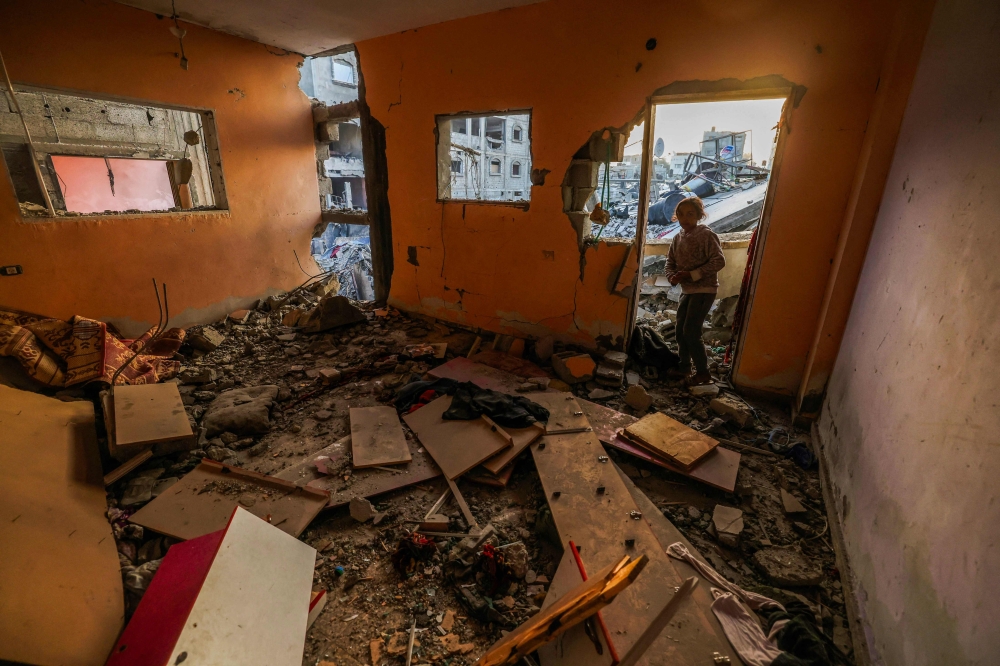A girl stands at the door of a house destroyed in Israeli bombardment in Rafah refugee camp, south of the Gaza Strip, on January 1, 2024. (Photo by AFP)
 