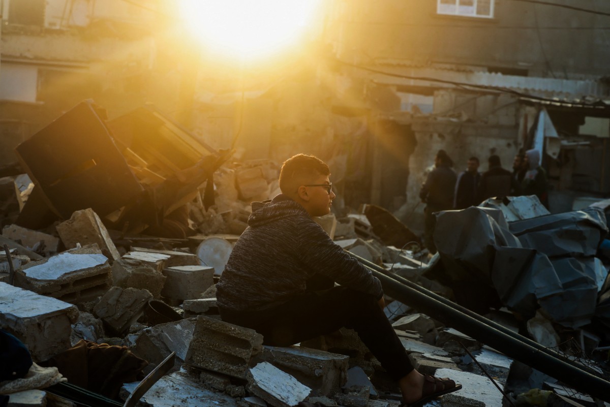 A boy sits on the rubble of a building destroyed by Israeli bombardment in Rafah refugee camp, south of the Gaza Strip, on January 1, 2024. Photo by AFP