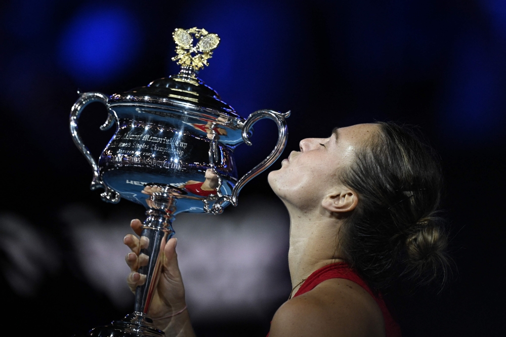 Belarus' Aryna Sabalenka kisses the Daphne Akhurst Memorial Cup after victory against China's Zheng Qinwen during their women's singles final match on day 14 of the Australian Open tennis tournament in Melbourne on January 27, 2024. (Photo by Lillian SUWANRUMPHA / AFP)