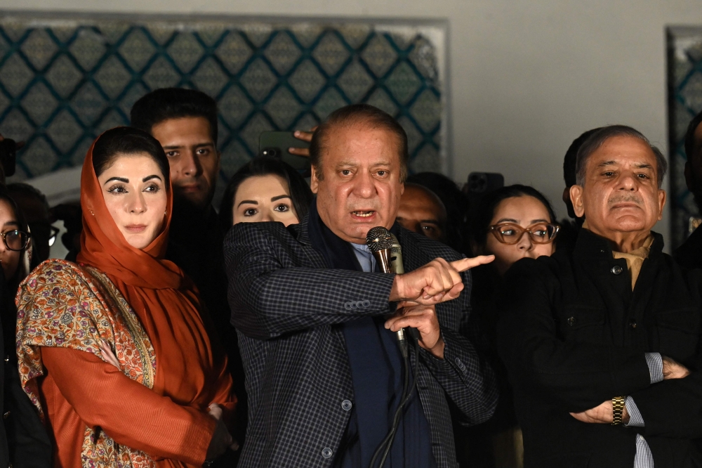 Pakistan's former Prime Minister Nawaz Sharif (C) and leader of the Pakistan Muslim League (PML) party, along with his younger brother and former prime minister Shehbaz Sharif (R) and his daughter Maryam Nawaz (L) speaks with supporters in Lahore on February 9, 2024, a day after Pakistan's national elections. (Photo by Aamir Qureshi / AFP)