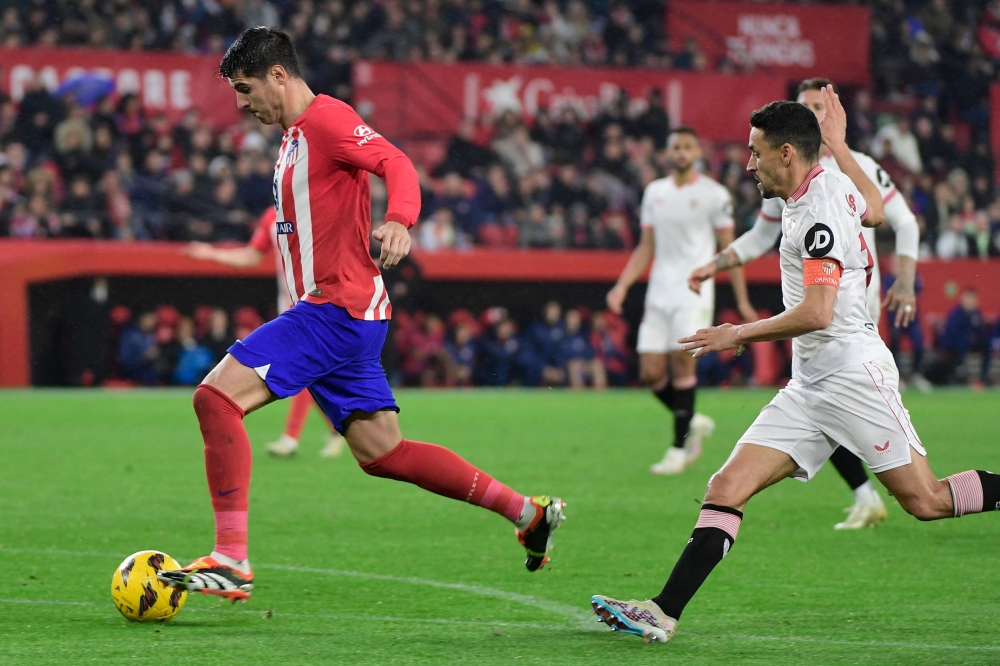Atletico Madrid's Spanish forward #19 Alvaro Morata (L) is challenged by Sevilla's Spanish midfielder #16 Jesus Navas during the Spanish league football match between Sevilla FC and Club Atletico de Madrid at the Ramon Sanchez Pizjuan stadium in Seville on February 11, 2024. (Photo by CRISTINA QUICLER / AFP)