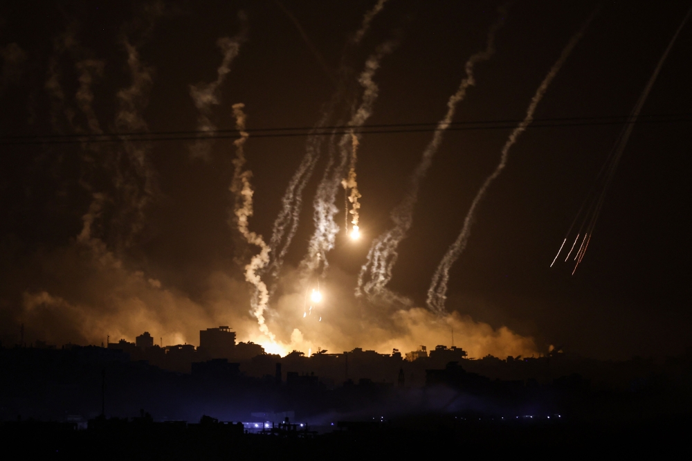 This picture taken from the Israeli side of the border with Gaza on November 10, 2023, shows smoke and flares dropped by Israeli forces over the Gaza Strip. (Photo by Kenzo TRIBOUILLARD / AFP)
