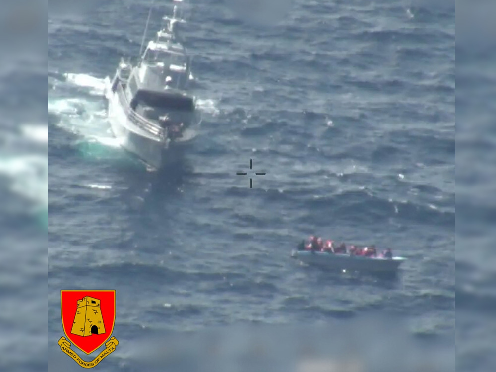 This handout picture released by the Armed Forces of Malta (AFM) on February 23, 2024 shows a patrol boat near of boat of migrants off Malta during a rescue operation. (Photo by Handout / Armed Forces of Malta / AFP)