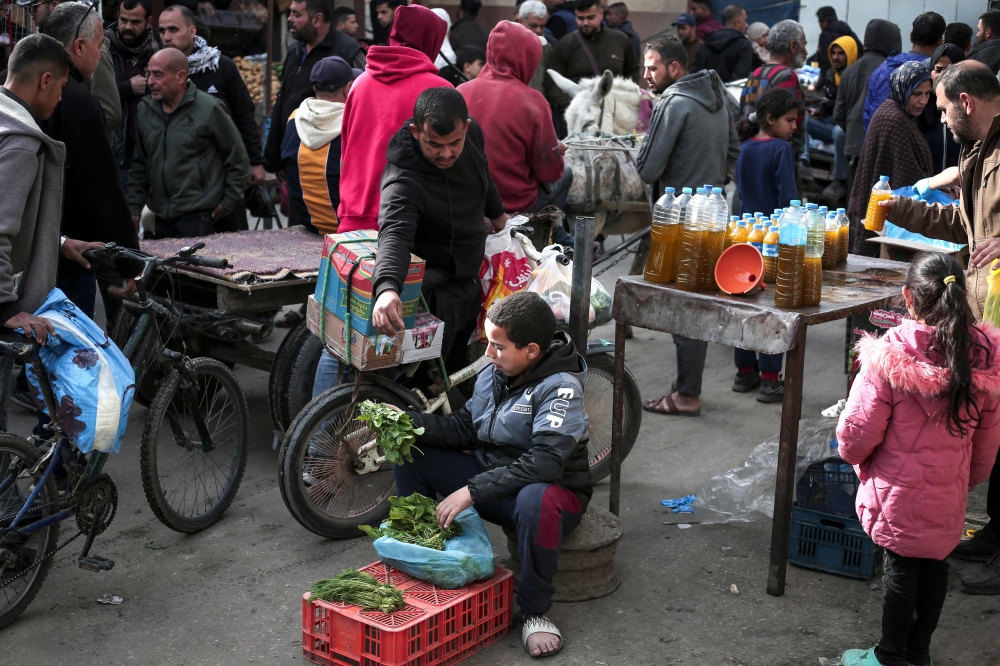 Palestinians buy and sell in a commercial street in Rafah in the southern Gaza Strip on March 1, 2024, amid ongoing battles between Israel and the Palestinian Hamas movement. (Photo by AFP)
