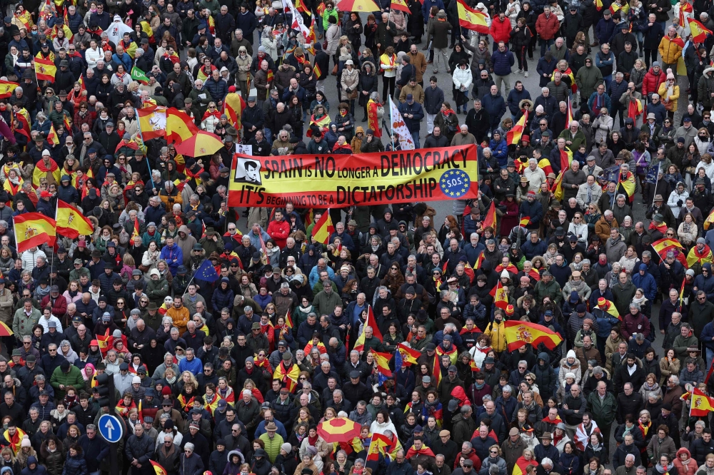 Protestors hold a banner reading 