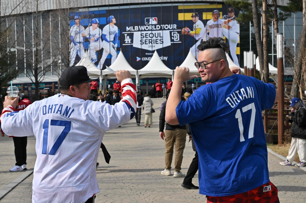 Fans of Los Angeles Dodgers player Shohei Ohtani pose for photos in front of the Gocheok Sky Dome in Seoul on March 20, 2024, ahead of the 2024 MLB Seoul Series baseball game between Los Angeles Dodgers and San Diego Padres. (Photo by Jung Yeon-je / AFP)