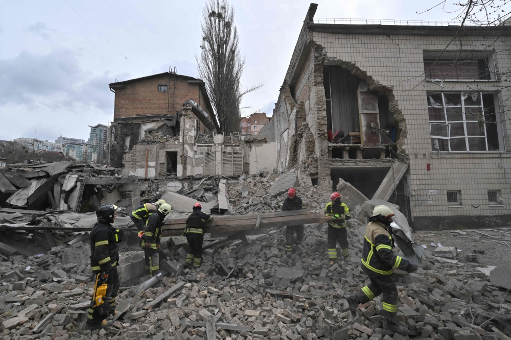 Ukrainian rescuers work at the site of a missile attack in Kyiv on March 25, 2024, amid the Russian invasion of Ukraine. (Photo by Sergei Supinsky / AFP)
